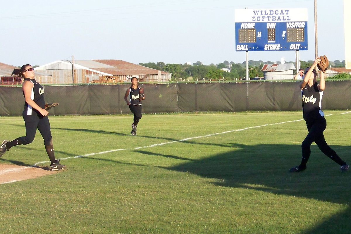 Image: Drew Windham, Junior 1st Baseman — Windham moves into foul territory to make the catch for an out.  Jeffords and Sophomore, Mariesella Perez come in to back her up.