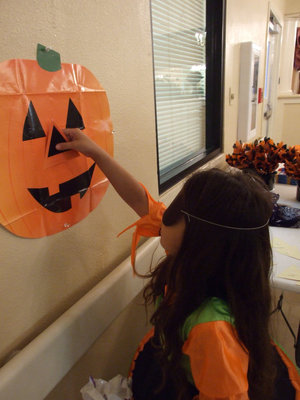 Image: Game player — In the middle of playing Pin the Nose on the Pumpkin.