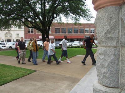 Image: Walking Tall — Assistant Coaches Josh Ward and Larry Mayberry step into the Waxahachie Courthouse along with the team.