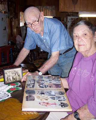Image: Days Gone By — Ray and Georgia Cavender of reminisce about the past as they look at family photos.