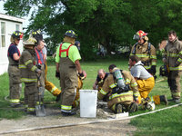Image: Community Firemen — Chief Chambers was searching through some ashes looking for clues as to what caused the fire.