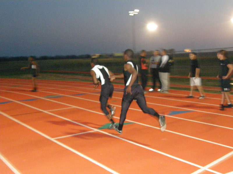 Image: Anderson to Moore — Jasenio Anderson and Darrin Moore execute their exchange during their relay event.