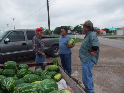 Image: Watermelon or Texas sized grape? — Luciano Garza on the left and Leo Garza on the right have a laugh or two with customers while they select just the right watermelon, or a grape if your from Texas.