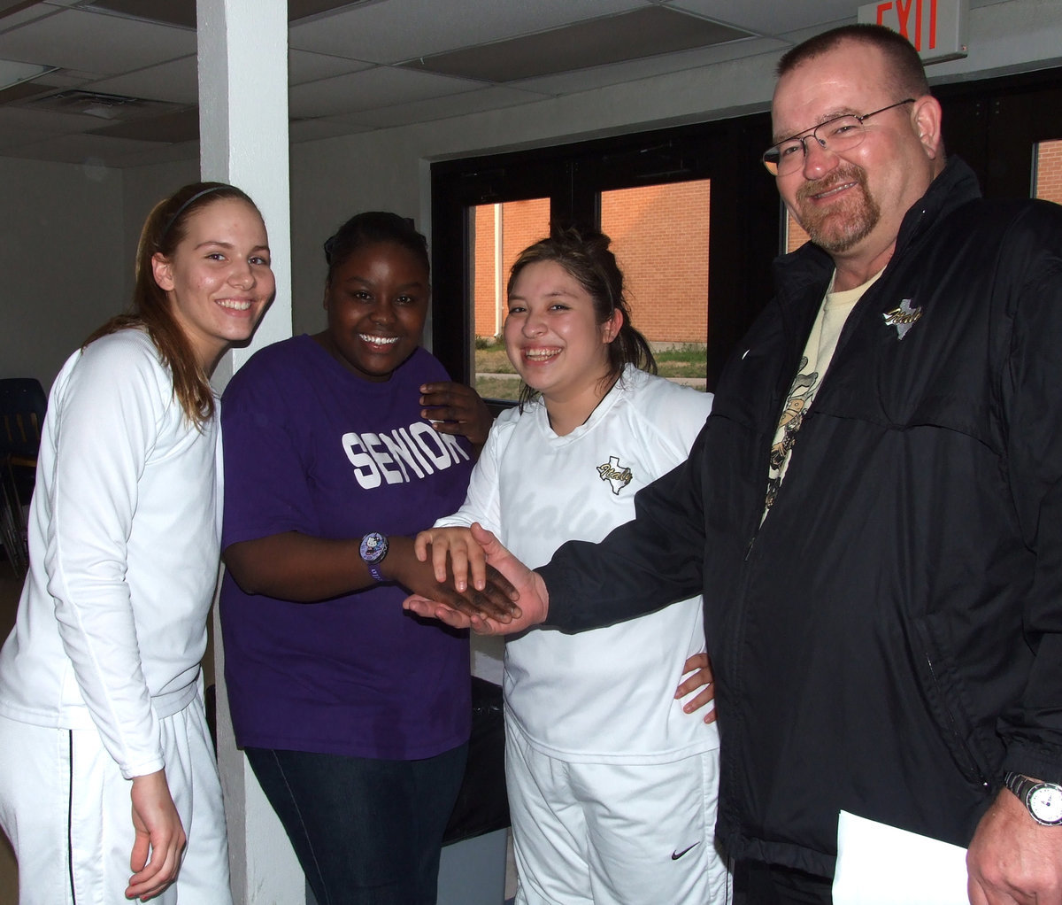 Image: Congrats from Coach — Coach Sollers congratulates the Seniors and wishes them the best of luck as they move forward. Becca DeMoss, Shanta Thomas and Blanca Figueroa represent Italy High School with class.