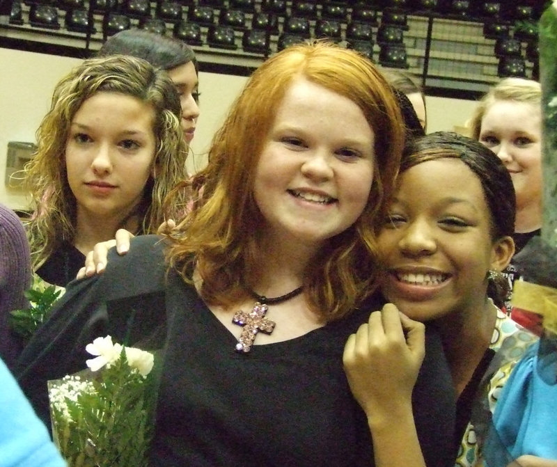 Image: Honorees embrace — Morgan Cockerham, Monserrat Figueroa, Katie Byers, Ryisha Copeland and Jessica Wilkins are savoring the moment as the 7th and 8th grade girls receive their personalized carnations.