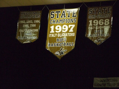 Image: Unvailing the banner — The banner recognizing the 1982-1986 Regional Qualifying Basketball Teams is now displayed high inside the Italy Coliseum along with the 1997 State Champions and 1968 State Semi-Finalist banners. Former Head Italy Cheerleader Andi Windham did the honors.