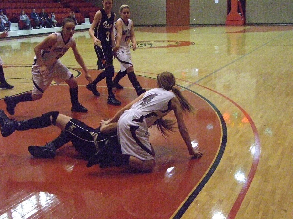 Image: Fight To The Finish — Becca DeMoss scrambles after the loose ball hitting the deck hard but manages to stay in the game. DeMoss would later nail 2 winning free throws in the final seconds.