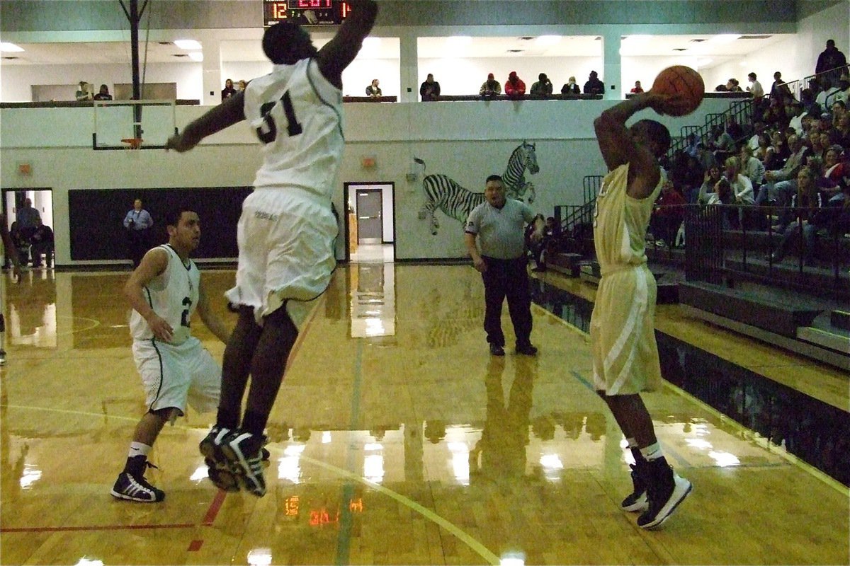 Image: “2” easy — Gladiator Heath Clemons(2) hits this 3-point attempt over a leaping Zebra.