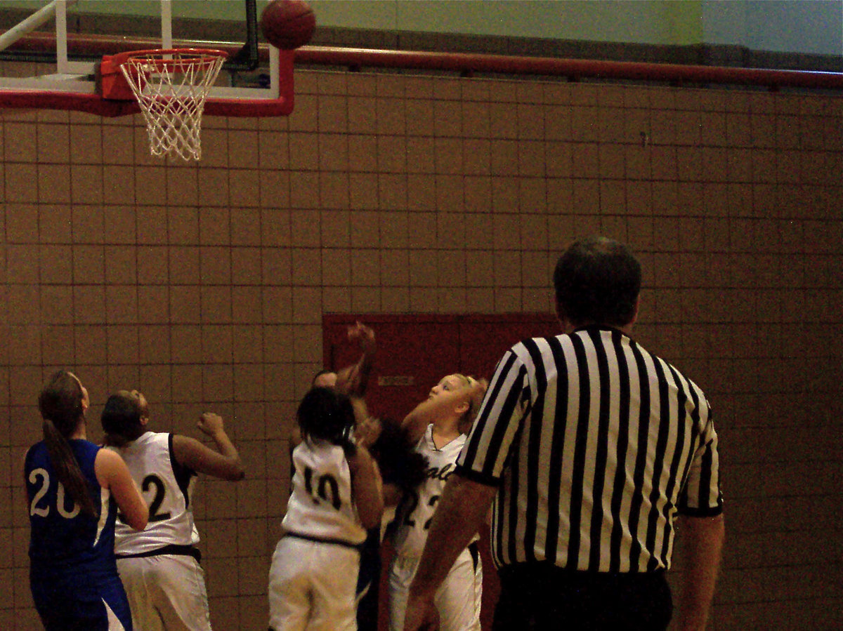 Image: Not In Our Lane — A Bulldog shooter gets mauled in the paint by the Lady Gladiators.