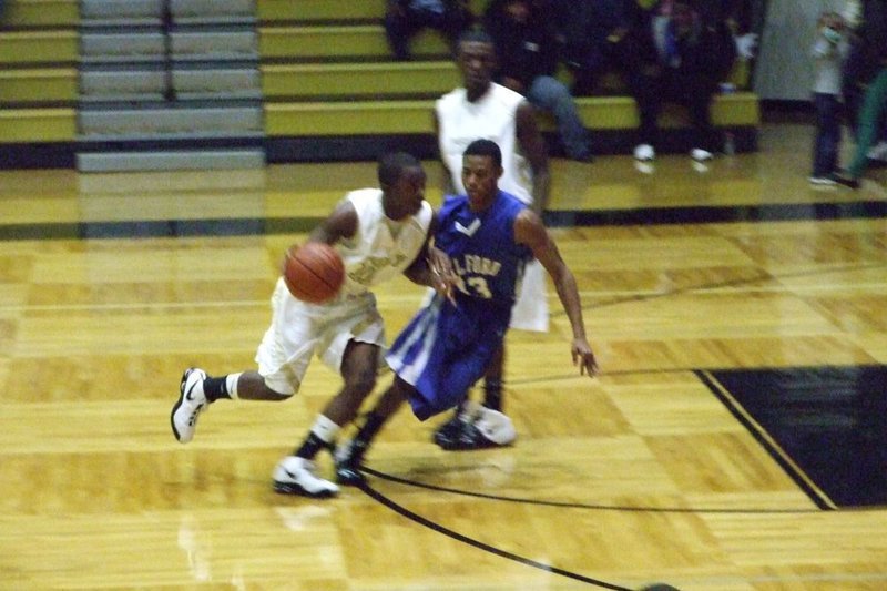 Image: Jasenio Makes His Move — Jasenio Anderson #11 drives into the lane against the Milford defense as Diamond Rodgers #4 tries to set the screen.