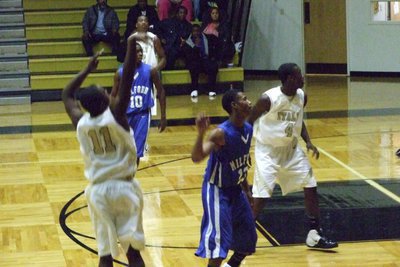 Image: Jasenio Anderson Launches — Sophomore Jasenio Anderson #11 shoots a 3-point try in Tuesday’s game against Milford.