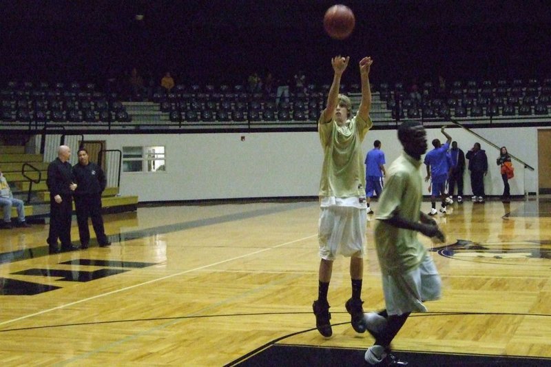 Image: Target Practice — Colton Campbell #13, acquired from the  Italy J.V. squad, warms up before the game against Milford. Campbell would later score in the contest, nailing a momentum turning 3-pointer, to help his Gladiator squad be victorious.