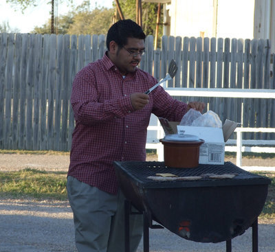 Image: Hamburger Time — The band members and parents sell concessions during the football games.  Mr. Perez makes sure there are hamburgers to sell during the JV games.