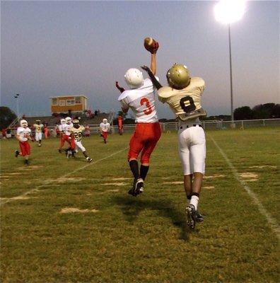 Image: Up in the air — Axtell defends a pass intended for Italy’s Trevon Robertson(9).