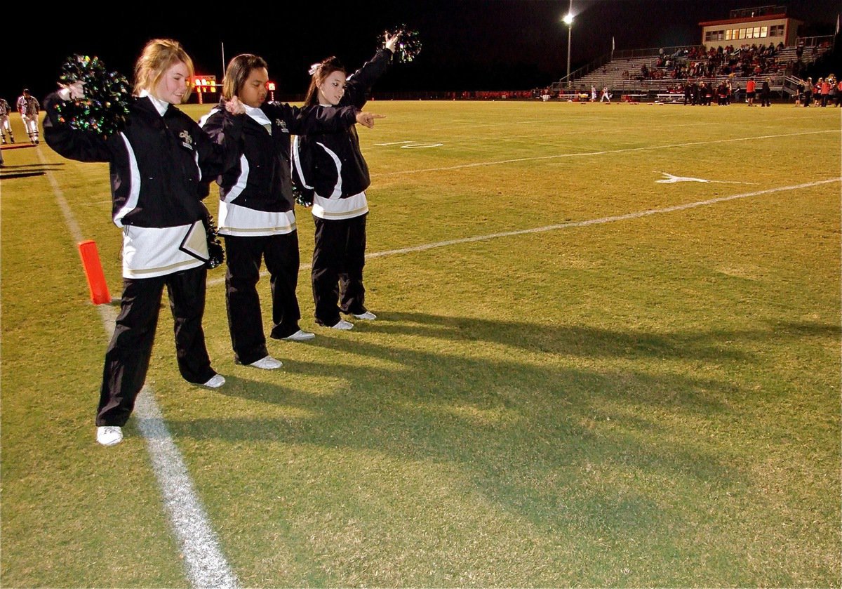 Image: Cool shadow — Italy High School Cheerleaders Taylor Turner, Destani Anderson and Haylee Love admire their shadows casting across Ellison Field in Axtell.