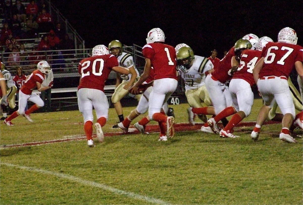 Image: All night long — Axtell’s quarterback Justin Stranacher(1) hands off to fullback Brandon Bordovsky(20)….or does he? The Longhorns ran the triple option offense and kept the Gladiators guessing on defense.