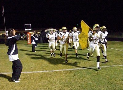 Image: Here they come! — Anna Viers and the IHS Cheerleaders welcome Jasenio Anderson(11), Heath Clemons(2), Omar Estrada(56), Jase Holden(6), Ethan Simon(50) and the rest of the Gladiators out to start the second half.