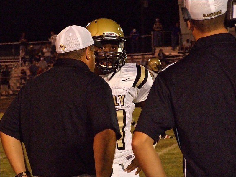 Image: Getting the play — Gladiator head coach Craig Bales gives Jasenio Anderson(11) the play call.
