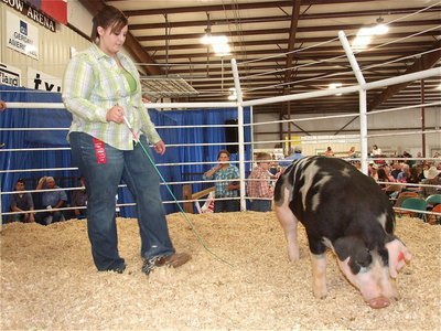 Image: Haley’s in the sale — Haley Pittmon shows her hog to potential buyers during the sale.