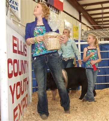 Image: A little help — Jesica Wilkins and Courtney Riddle help out Abby Griffith while she shows her hog during the sale.