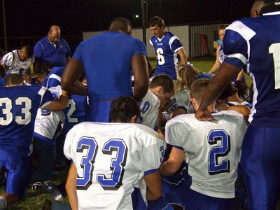 Image: Sharing a moment — Both sides join in a prayer lead by Milford’s Jacob Rose(6).