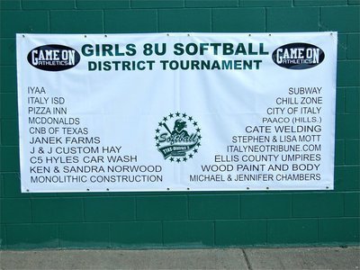 Image: Banner day — Girls 8u Softball District Tournament banner donated by Game On Athletics displays tournament sponsors. “CHAMPIONS” will be added and presented to the winning team.