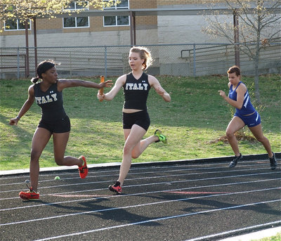 Image: In the lead — Practice pays off as Sierra Harris passes the baton to Kendra Copeland during the 400 meter relay. Harris, Copeland, Jameka Copeland and Ryisha Copeland finished first in the event with a time of 55.43.
