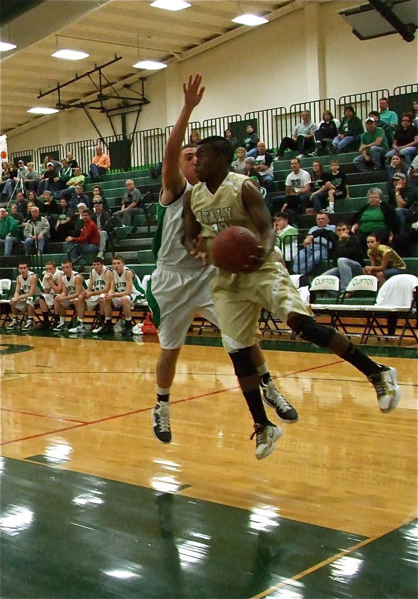 Image: Court awareness — Jasenio Anderson(11) drives under the hoop and passes back to a teammate for a Gladiator score.