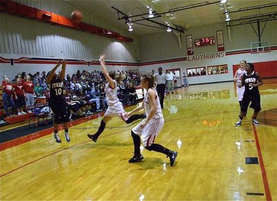 Image: Triplet #1 — Lady Gladiator Keyonne Birdsong(10) drills a three-pointer with a Lady Longhorn charging her.