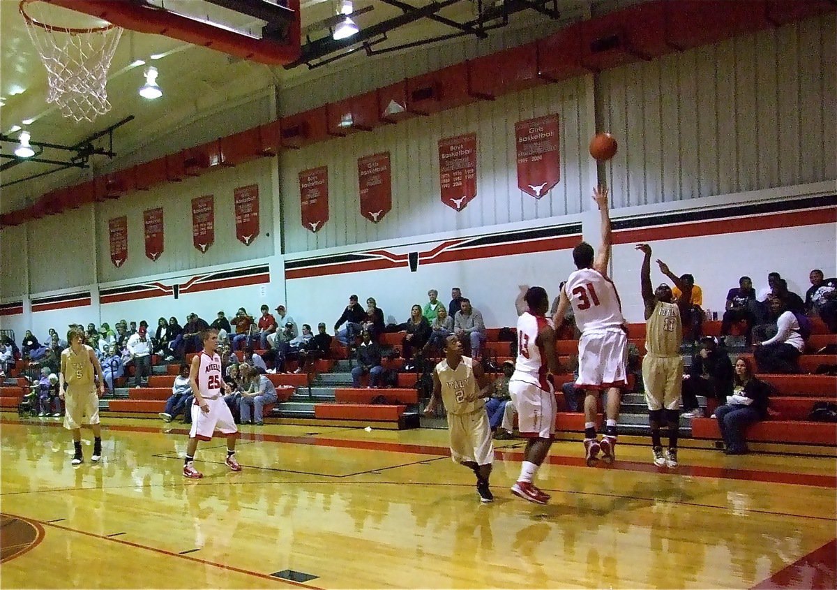 Image: From beyond the arc — Point guard Jasenio Anderson(11) swishes in a three-point bomb from the corner.