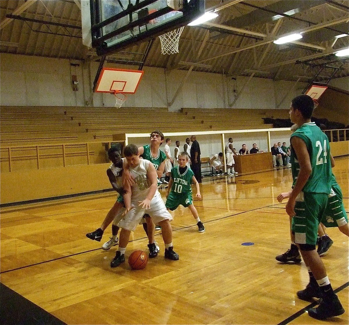 Image: Battling the boards — Zain Byers(50) tries to secure a defensive rebound with a Clifton Cub clawing away.