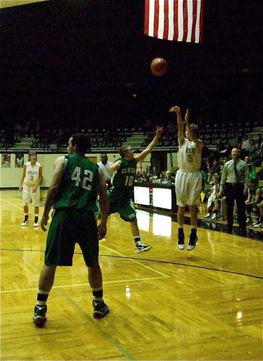 Image: Camping out — Gladiator Colton Campbell(5) takes a three-point shot with a Cubs’ paw in his face. Campbell finished with 8-points against Clifton.