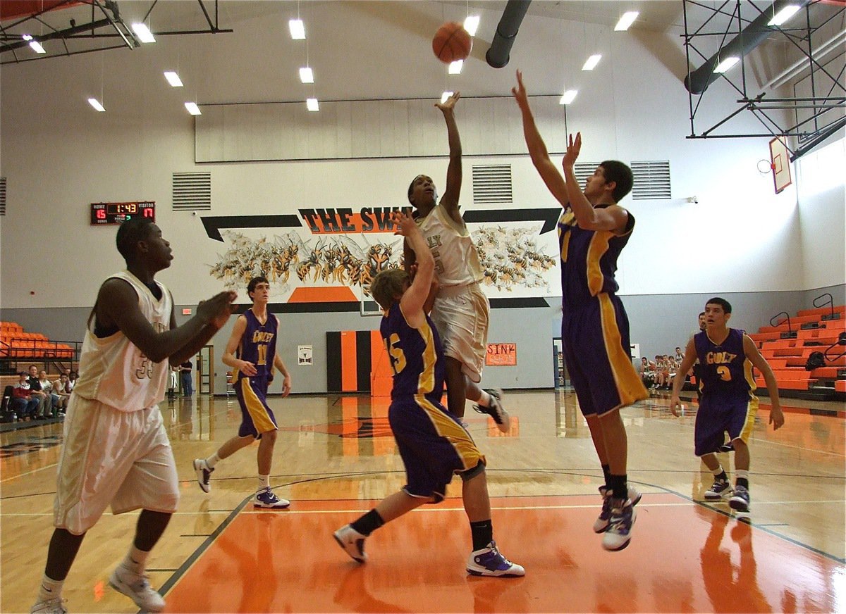 Image: Trevon Robertson(15) goes over the top as Italy’s JV team  — Italy’s Trevon Robertson(15) attacks the middle of the lane against Godley while T.J. Cockran gets in position to grab a board. The Italy JV Gladiators won 3-out-of-4 games to finish in 3rd place during the Ferris JV Tournament.