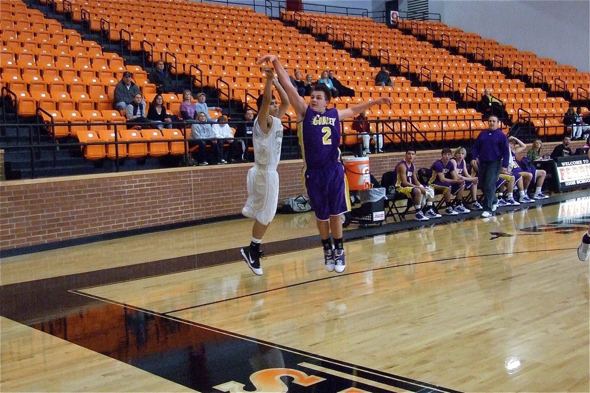 Image: Reid releases a shot — Reid Jacinto(3) takes a 3-pointer over a Godley defender.