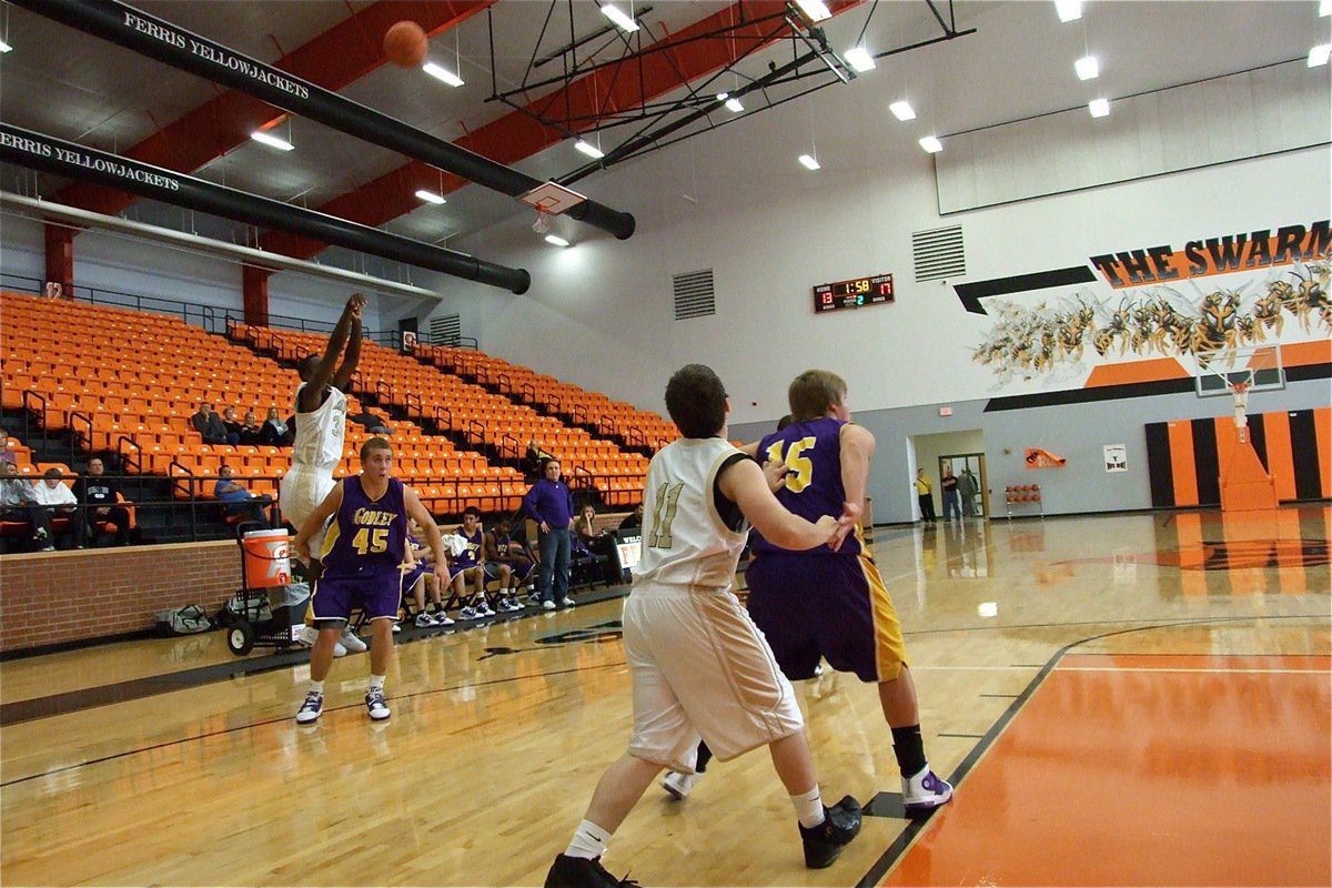 Image: How it’s done — T.J. Cockran(33) knocks down a triple against Godley during the third round of the Ferris Tournament as teammate Jake Escamilla(11) prepares to rebound.