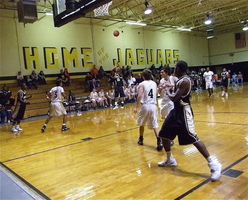 Image: Tre for three — Trevon Robertson(15) launches a 3-pointer from way outside as Paul Harris(55) gets in rebounding position.