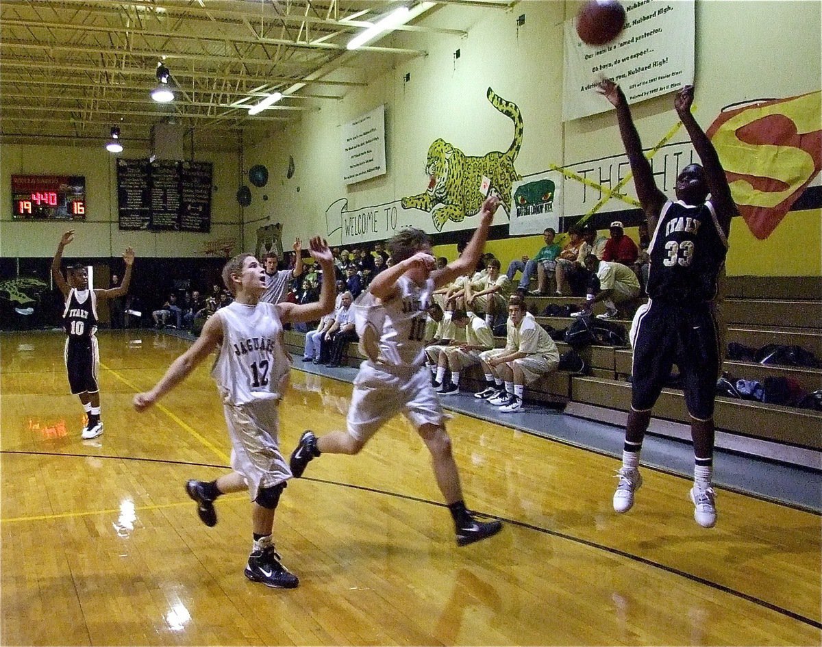 Image: From the corner — Travis Cockran(33) tries a 3-pointer from the corner with Jaguars on the chase.