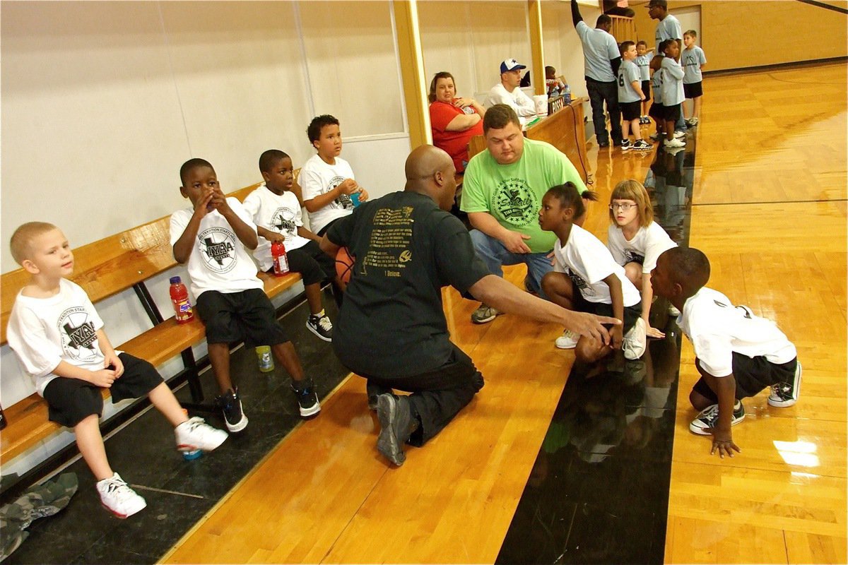 Image: Here’s the plan — Coaches Derrick Cunningham and Roy Stephens talk to their troops during a timeout.