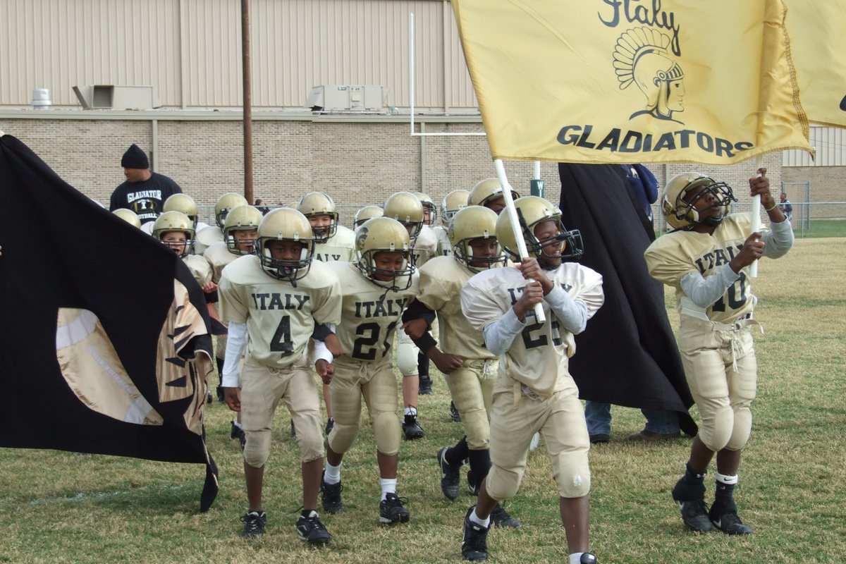 Image: The B-Team unites — The IYAA B-Team Gladiators are lead out by Ricky Pendleton(26), Taron Smith(10), Jaylon Davis(4), Zorian Burley(21) and Ja’Sean Brooks(11) to start their team’s conference championship playoff game against the Palmer Bulldogs.