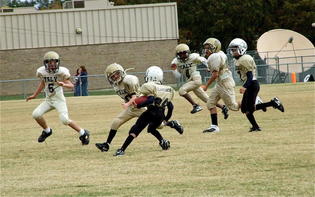 Image: Heel! — Italy’s Ryder Itson(6), Miguel Martinez(30), Donald Hayes(56) and Jaylon Davis(4) converge on a Palmer Bulldog runner.