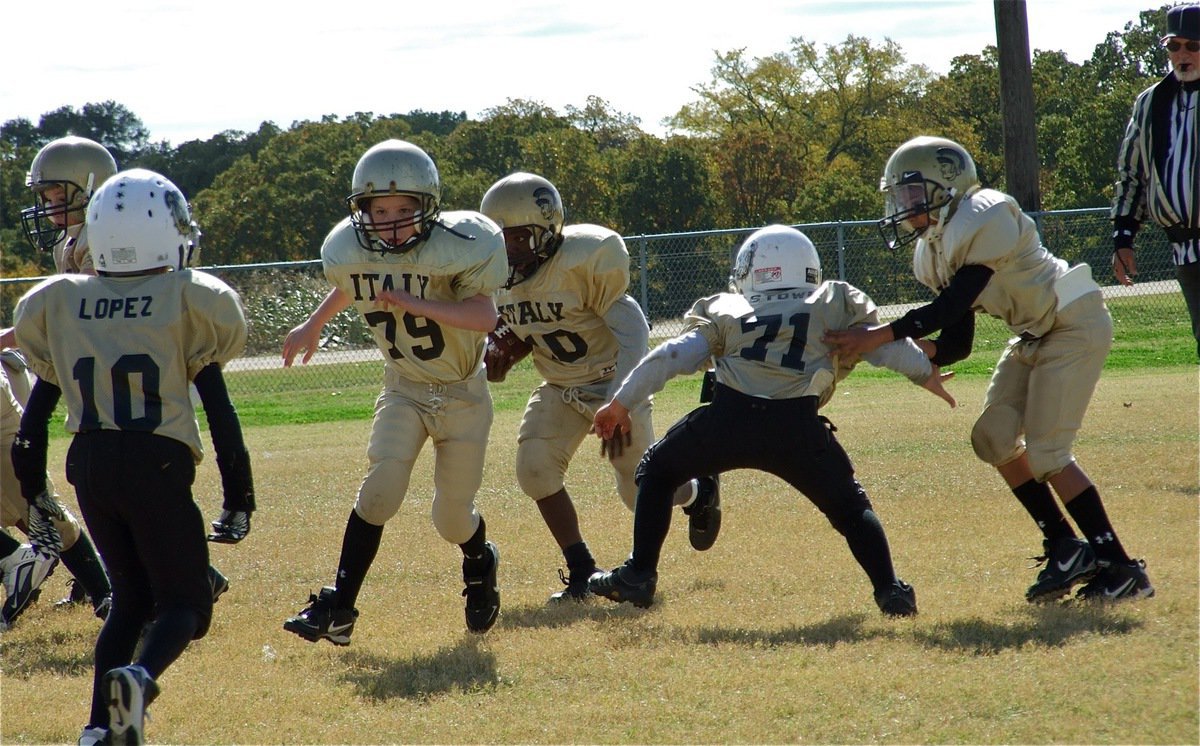 Image: Follow us! — IYAA B-Team blockers Jacob Wiser(8) and Brennon Sigler(79) lead Taron Smith(10) thru the hole.