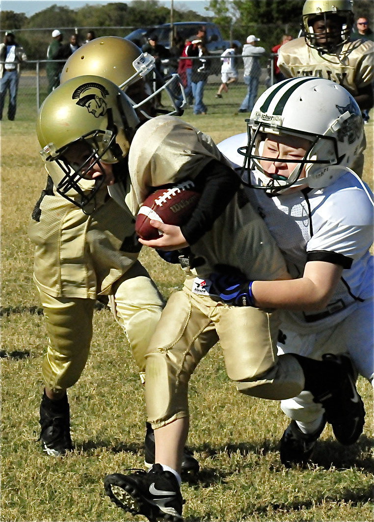 Image: Determined players — IYAA C-Team Gladiator Bryce DeBorde(44) carries the hopes of his team along with a Scurry-Rosser Wildcat defender on his back. Who wanted it more? Italy did!