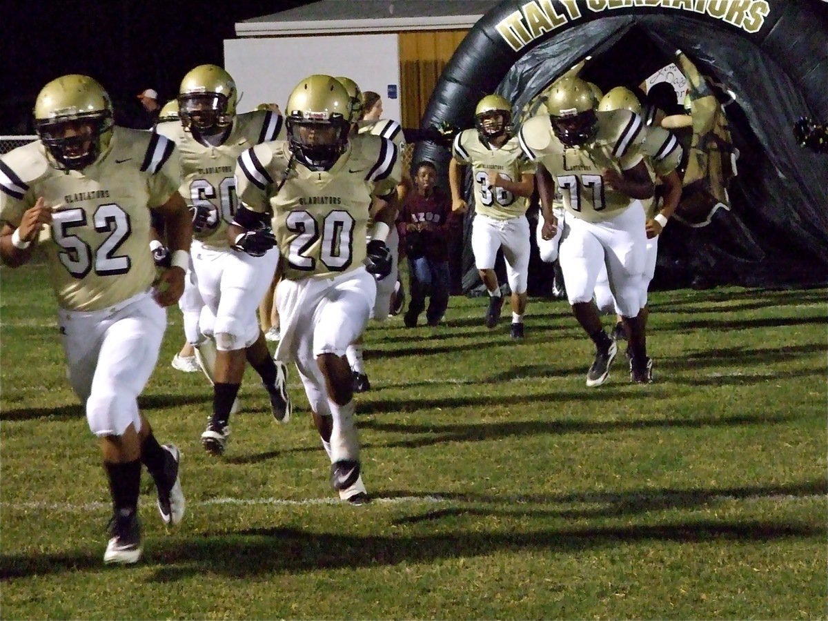 Image: The big entrance — The Italy Gladiators are lead onto Willis Field by Jacob Lopez(52), De’Andre Sephus(20), De’Andre Rettig(60), Larry Mayberry(77) and Tony Wooldridge(36).