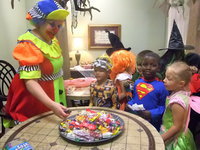 Image: Cute Trick or Treaters — These students are having fun talking with the clown and getting treats.