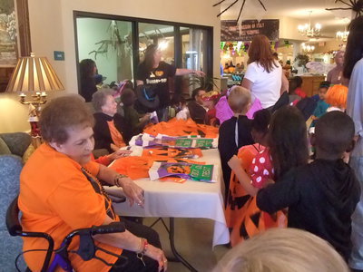 Image: Residents Enjoying the Students — Trinity Mission residents were busy handing out trick or treat bags.