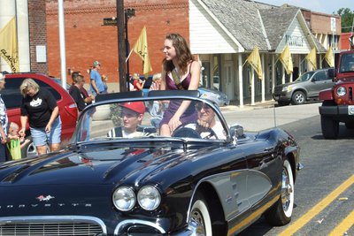 Image: Traveling in style — 2010 Homecoming King and Queen Nominees Melissa Smithey and Kyle Wilkins (red cap) cruise past Italy City Hall during the Homecoming parade.