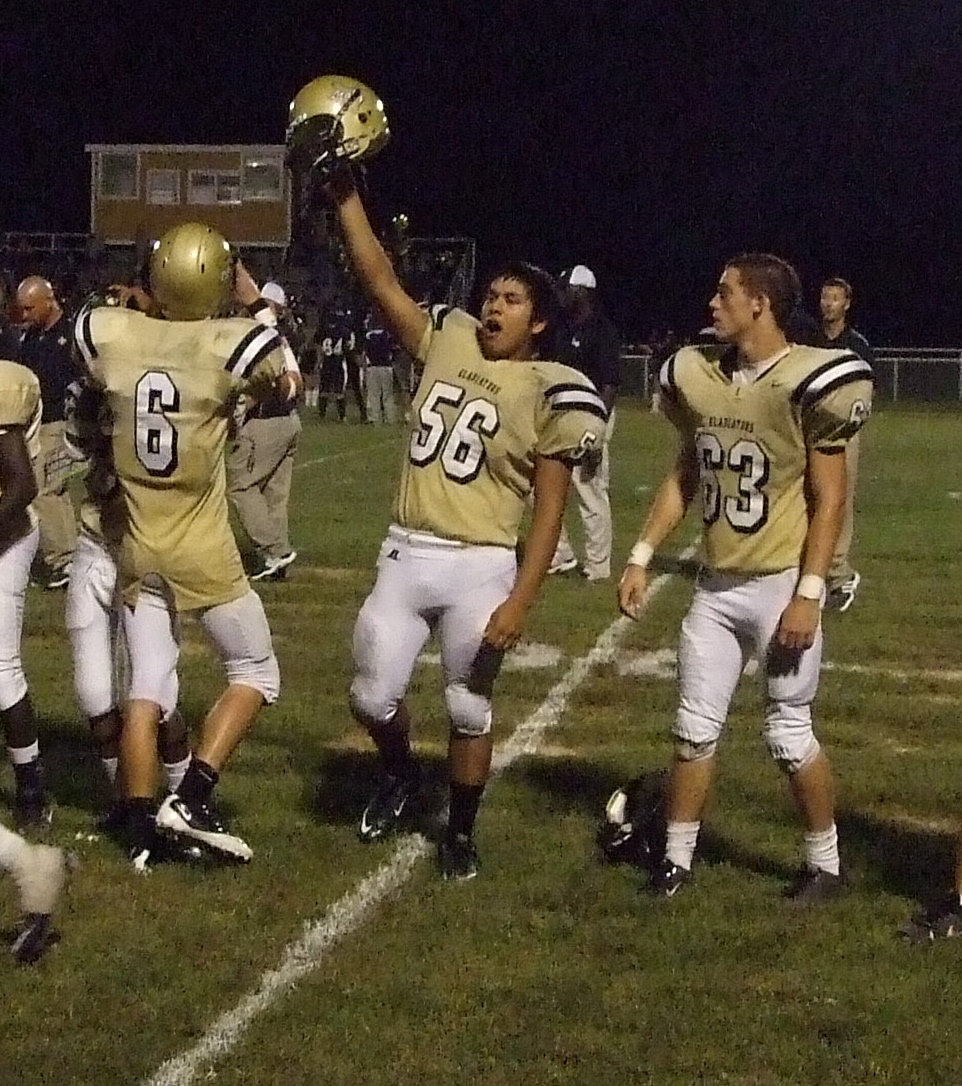 Image: The Gladiator yell — Omar Estrada (56) celebrates the Gladiator victory with Jase Holden(6) and Brandon Souder(63).