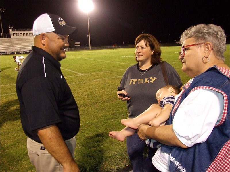Image: Celebrating with family — Gladiator athletic director and head football coach Craig Bales visits with his wife Jenny Bales and his mother Mary Bales after the win over Palmer. Kix Bales was unavailable for comment.