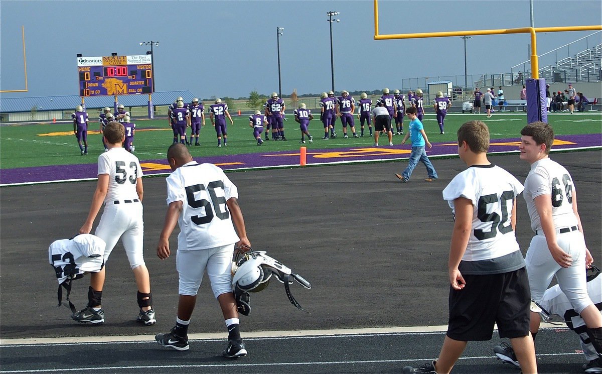 Image: The Italy JV squad arrives to play the Mart Panthers — Italy’s Bailey Walton(52), Darol Mayberry(56), Zain Byers(50) and Jake Escamilla cross the track and head toward Mart’s turf field where the Panthers were eagerly awaiting their arrival on Thursday.