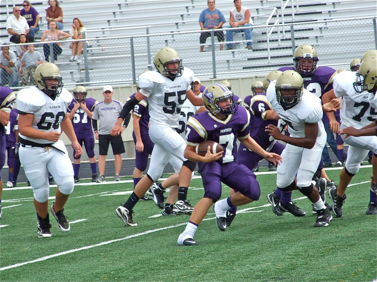 Image: Panther gets loose — The Panther quarterback looks for running room while being surrounded by Gladiators.